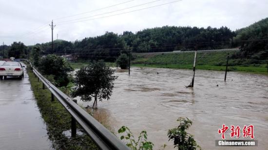 入汛以来，湖南多地先后降下暴雨。6月22日开始，湖南桃江县遭遇今年最强降雨，加之上游水库泄洪，资江桃江段水位连日来持续上涨，造成多地被洪水浸没。6月24日，桃江县警民联动，在洪水肆掠的地段，积极引导人流、车流，一道转移人员、物资，力争将洪灾损失降到最低。图为民警在水淹路段巡逻。 王鹏 摄