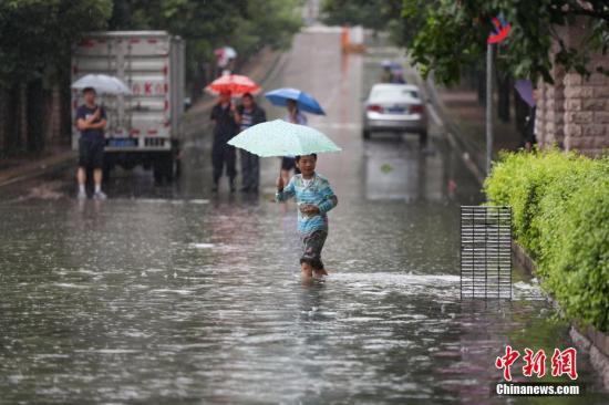 市民在积水的道路中出行。记者 贺俊怡 摄